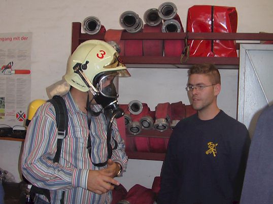 Besucher mit Helm und Atemschutzgerät